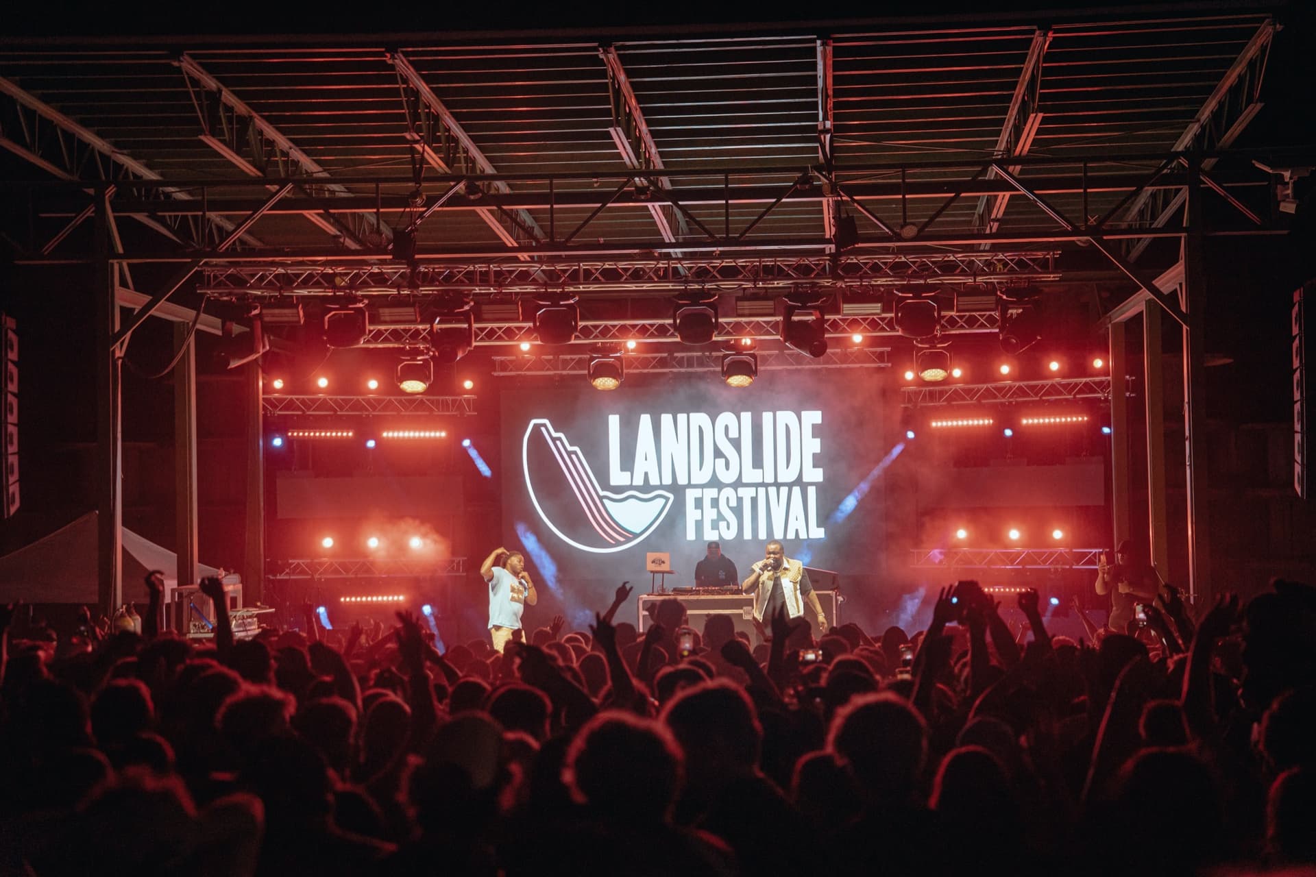 Landslide Festival stage at night with red lighting, crowd energy, and a large video backdrop.