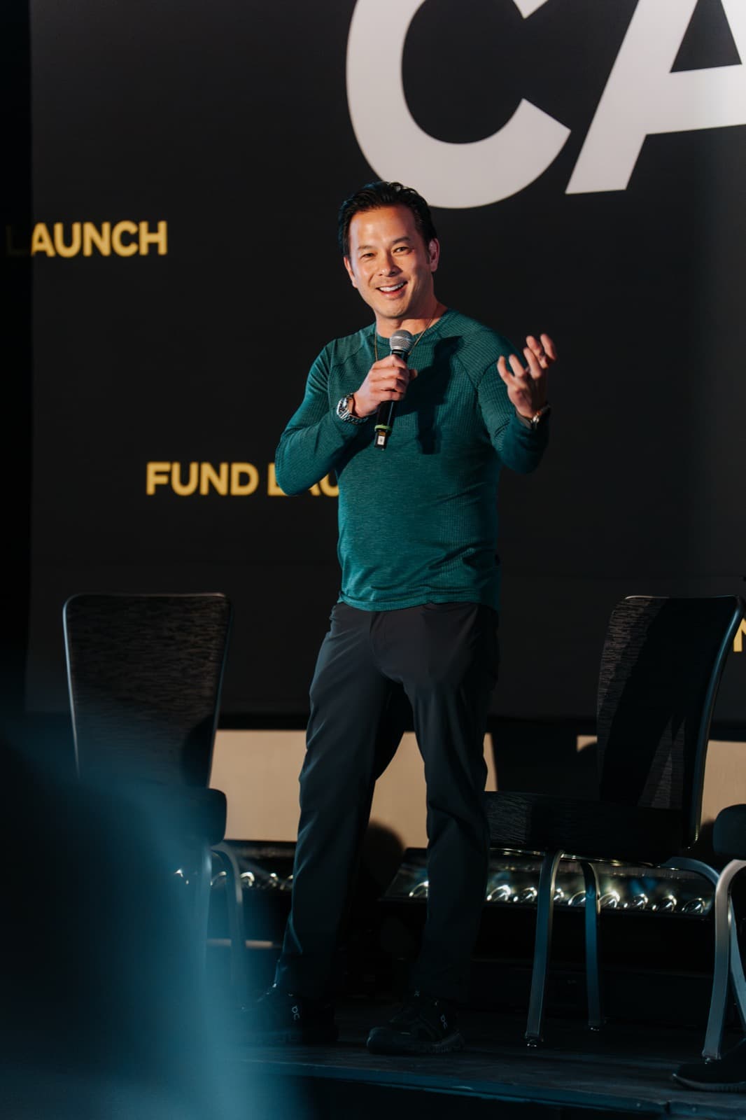 Presenter on the Black Card stage under focused lighting.