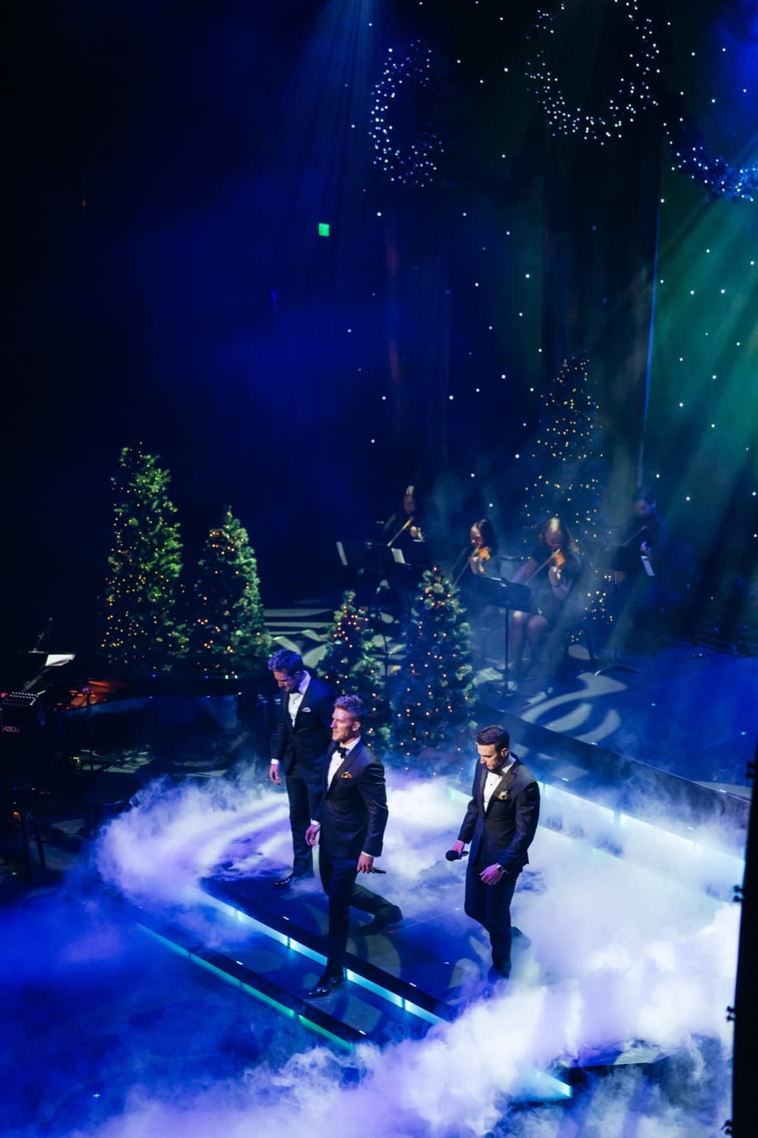 GENTRI stage with green and blue lighting, haze, and audience silhouettes.
