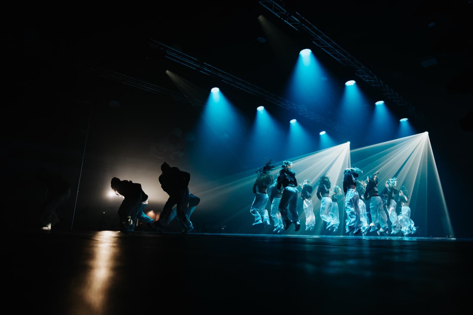 Blue spotlights and haze creating a dramatic Five World stage scene.