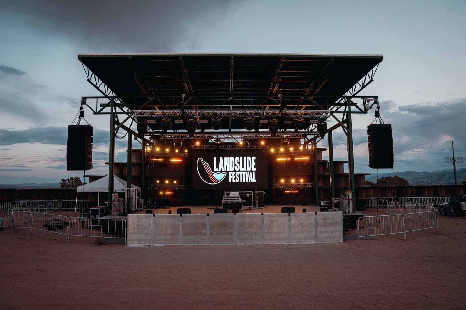 Daytime Landslide Festival stage setup with roof, lighting, and production equipment.