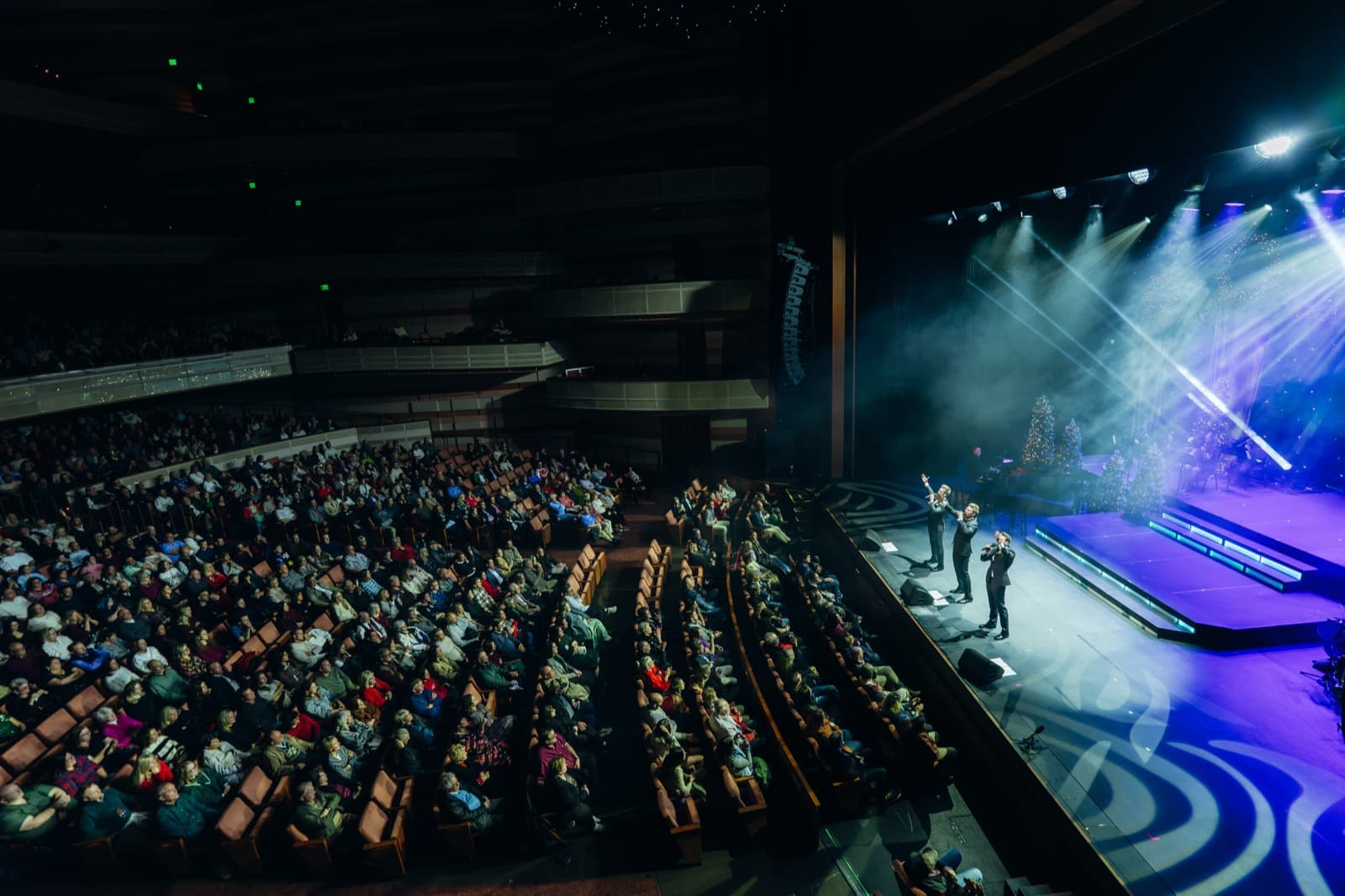 GENTRI concert audience view with sweeping green stage lights.