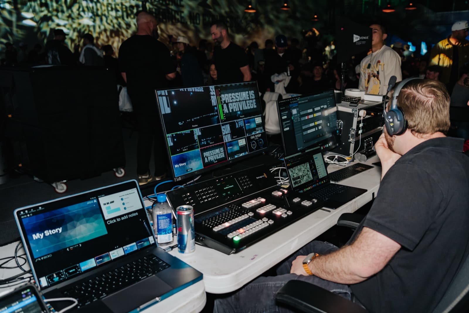 Aptive event production view with audience seating, stage wash, and LED screen content.