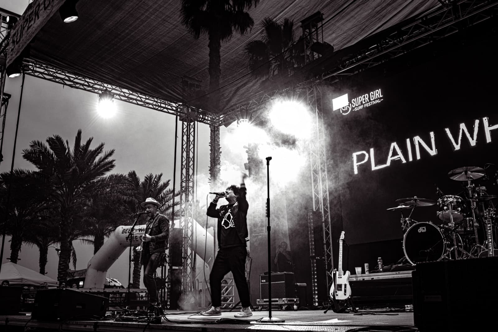Black and white Supergirl stage view with performer and venue branding.