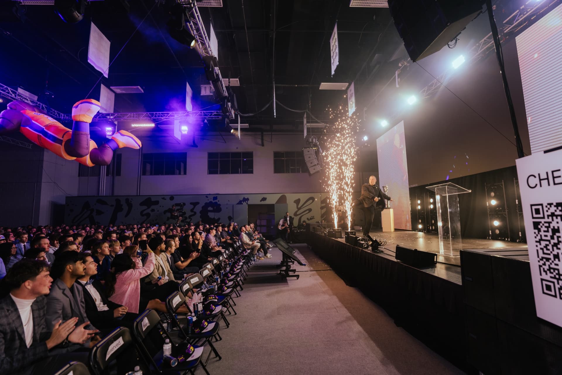 Aptive corporate awards stage with purple lighting, LED screens, and a seated audience.