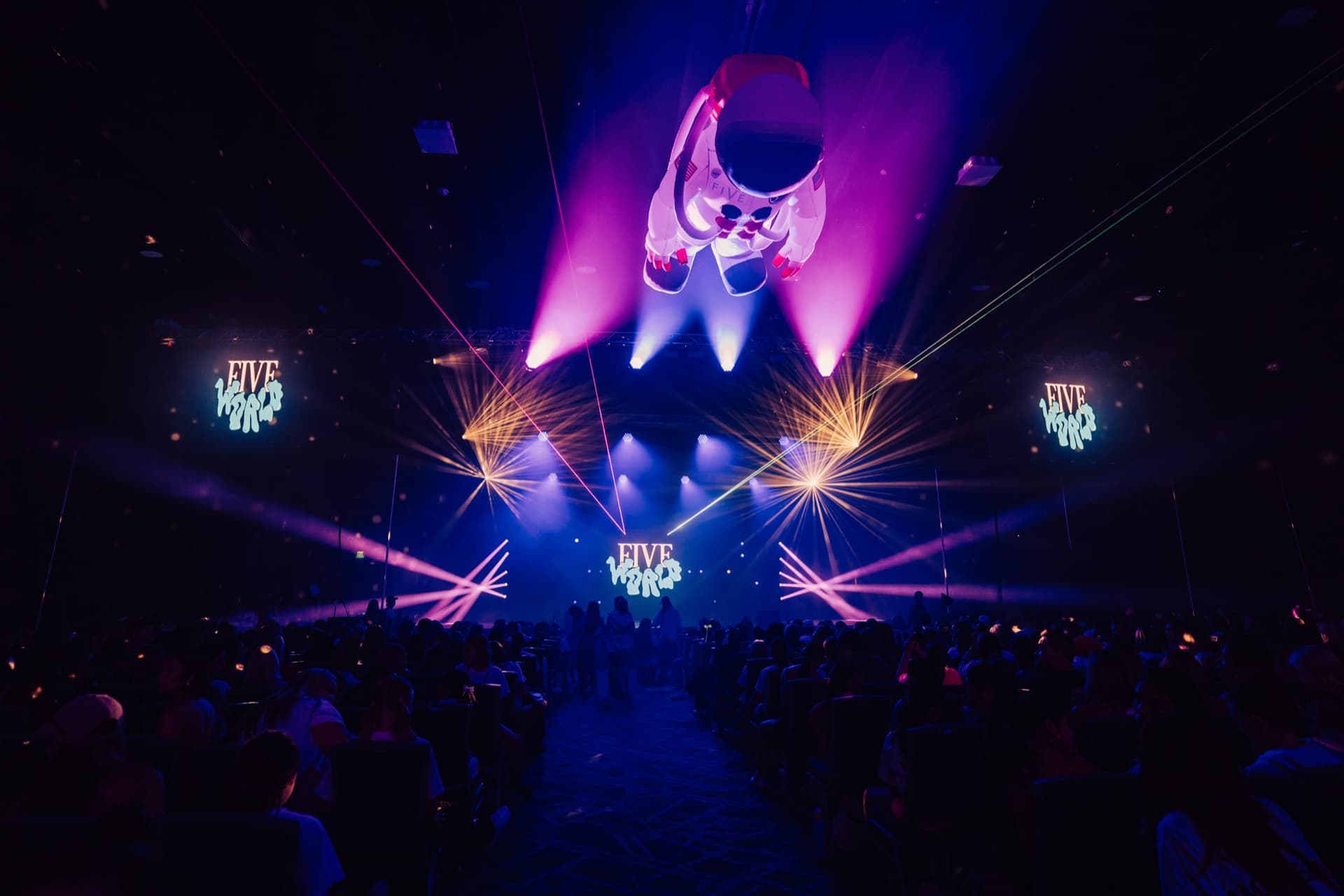 Five World stage with aerial performance, vivid concert lighting, and LED visuals.